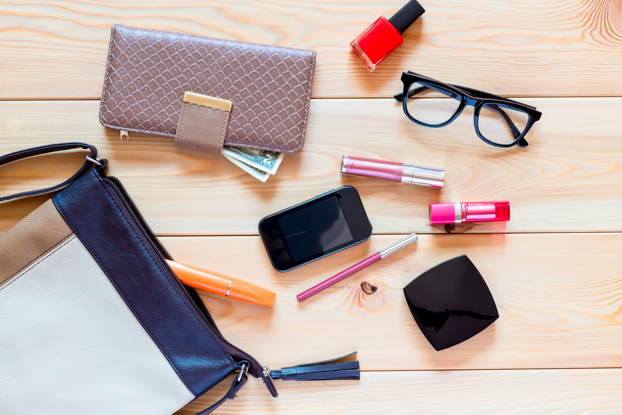 the contents of women's handbags are scattered on the floor