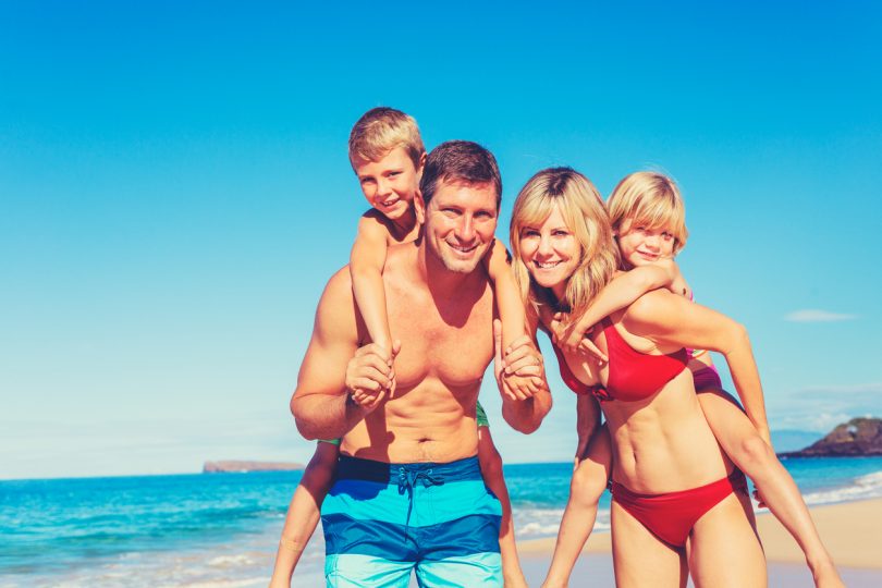 Happy family having fun on beautiful warm sunny beach.