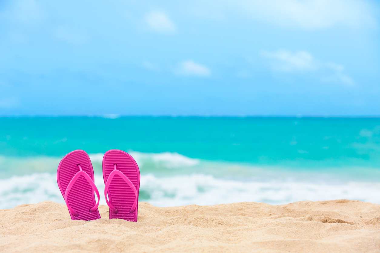 Pair of colorful slippers on the beach.