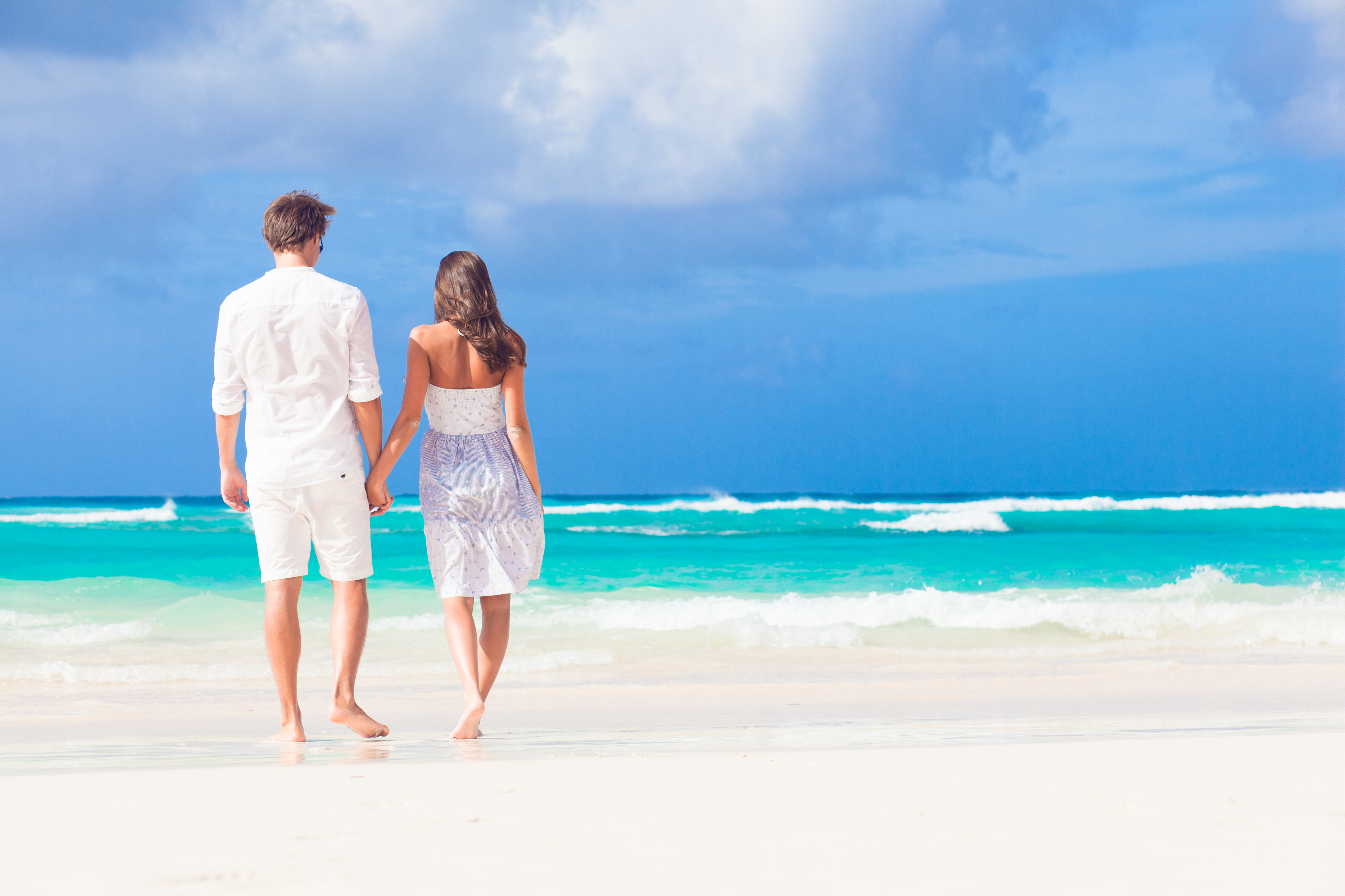 young happy couple in white at tropical beach. honeymoon