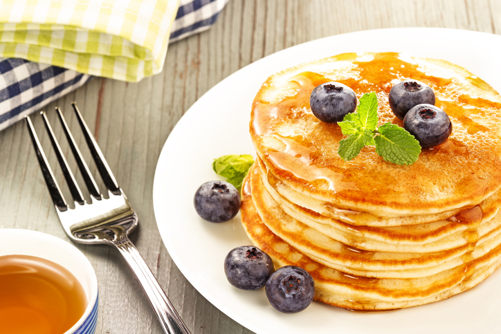 plate of stacked pancakes with fresh blueberries