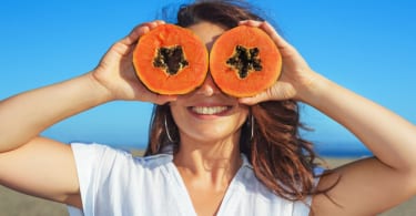 Adult woman hold in hands ripe fruit - orange papaya