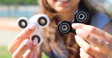 Smiling Women hold a white and black spinner