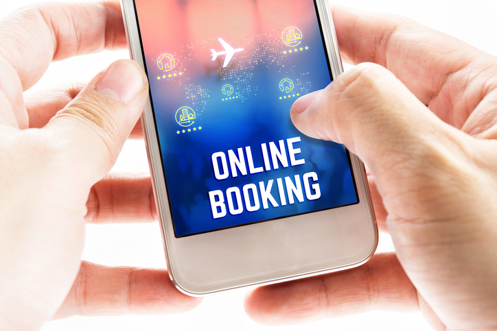 Close up Two hand holding mobile phone with online booking word and icons, Online Digital Marketing concept
