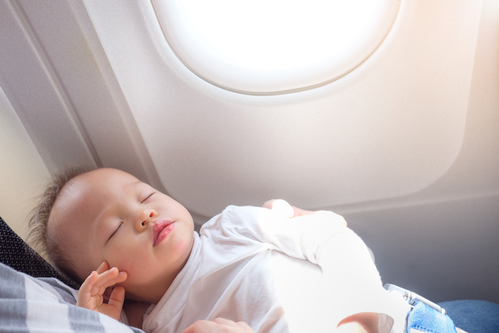 Cute little Asian 18 months / 1 year old toddler baby boy child sleeping on Airplane with copy space